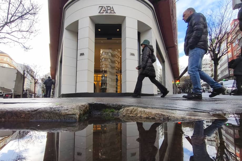 Varias personas caminan este viernes frente a la tienda de Zara que cerrará el 30 de enero, situada en la calle Juan Flórez de A Coruña. Se trata de la primera tienda que abrió Amancio Ortega en la historia de Inditex. / EFE/Cabalar