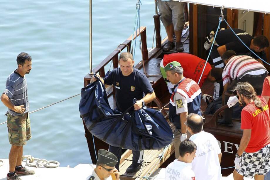 Miembros de la guardia costera turca cargan los cuerpos de las víctimas del naufragio en la costa del distrito de Menderes/ EFE