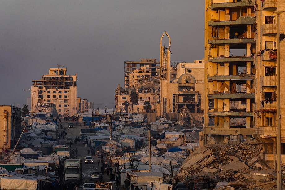Palestinos desplazados internos se desplazan entre las ruinas de edificios destruidos en la carretera Al Rashid, al oeste de la ciudad de Gaza.