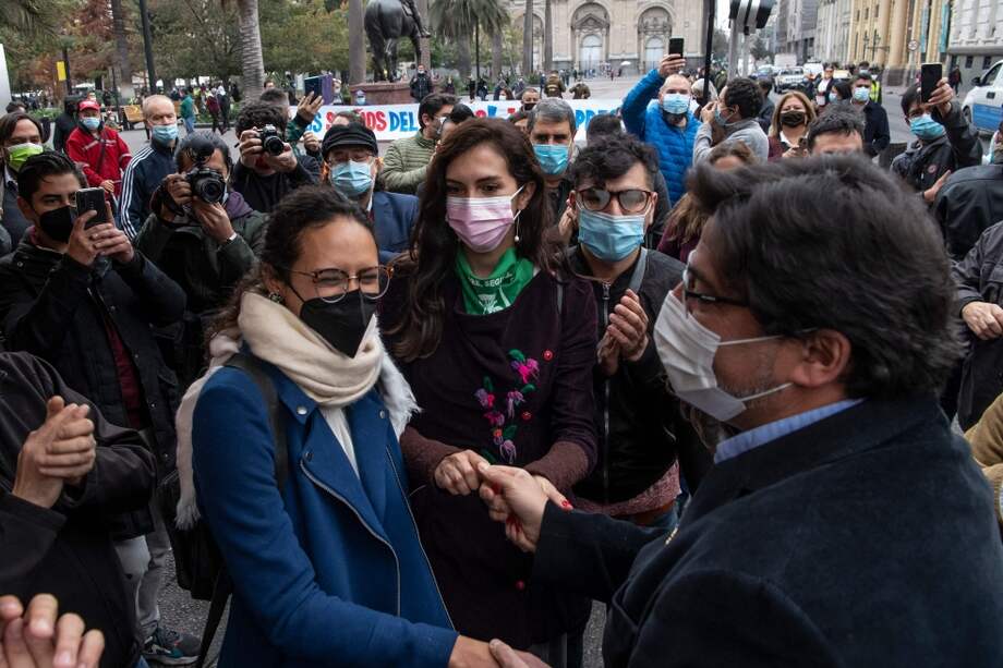 Dos mujeres elegidas como constituyentes en Chile saludan a políticos en Santiago.