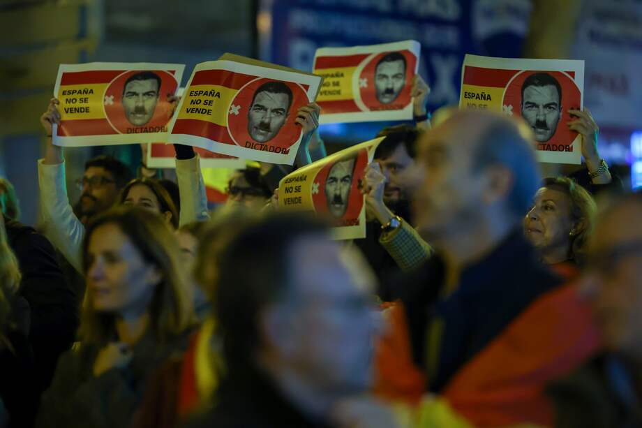 Centenares de personas participan en la manifestación convocada contra la amnistía y el Gobierno de Pedro Sánchez en las inmediaciones de la sede del PSOE, hoy martes en la madrileña calle de Ferraz.