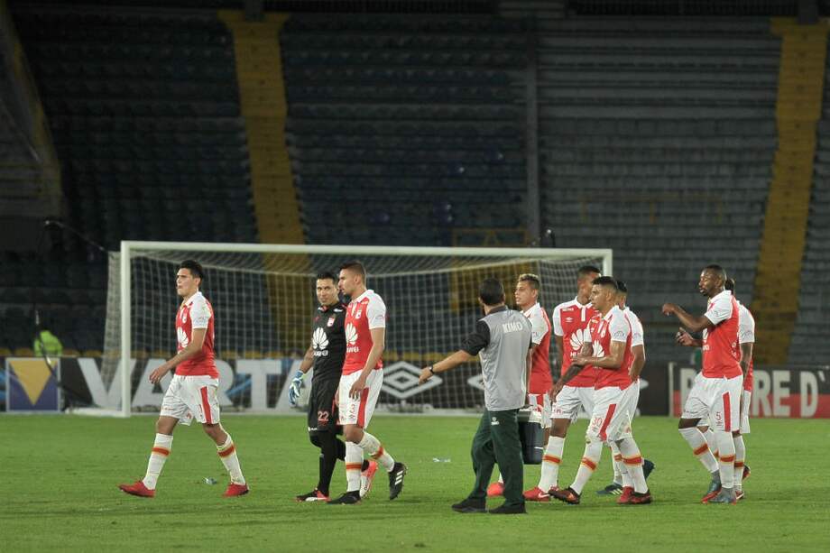 Los jugadores de Independiente Santa Fe abandonan el estadio tras la derrota frente al Huila.