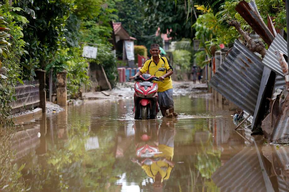 Los residentes evacúan sus pertenencias de una aldea afectada por las inundaciones en el área de Meureudu, Pidie Jaya Aceh, Indonesia.