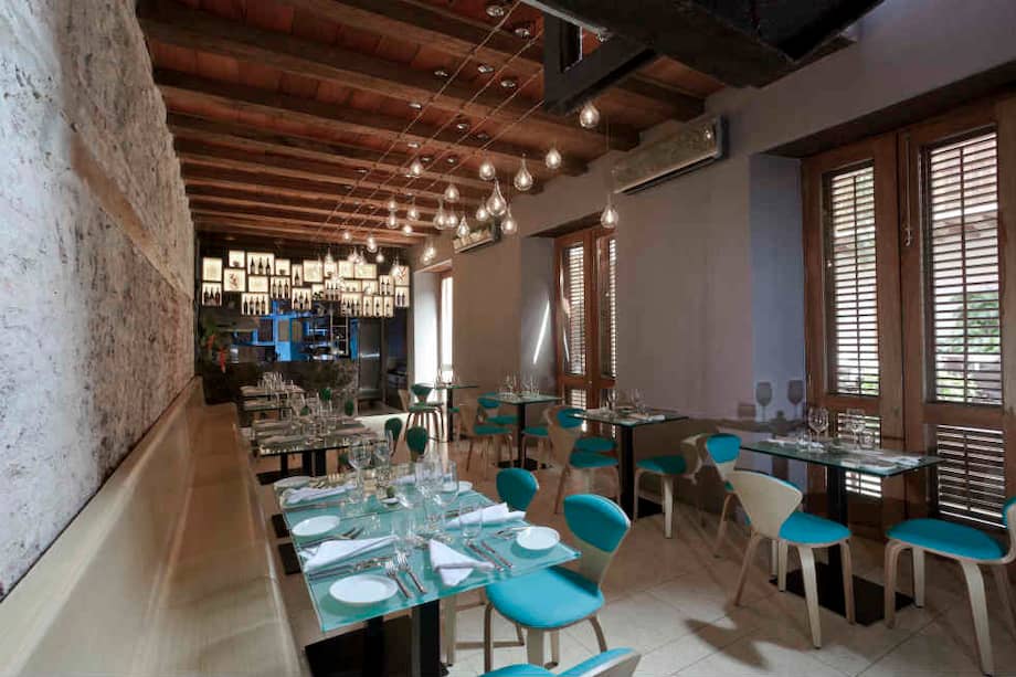 El comedor interior de Carmen en Cartagena, rodeado por un ambiente sencillo y cálido, ofrece una vista directa a la cocina. / Cortesía