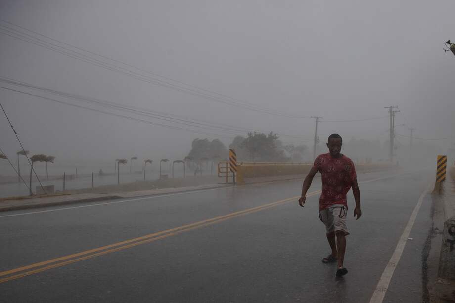Un hombre camina en medio de una intensa ráfaga de viento y lluvia durante el paso del huracán Fiona, hoy, en Nagua (República Dominicana).