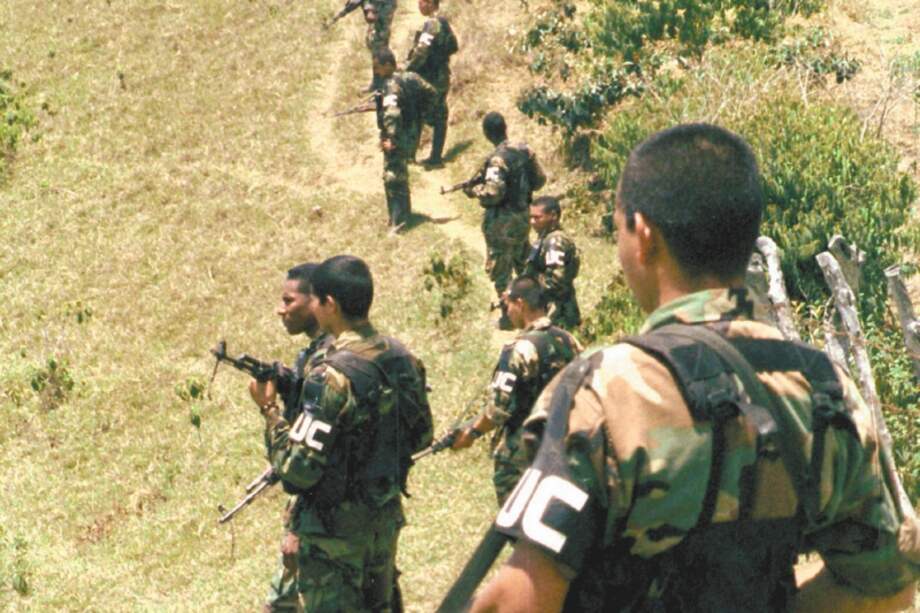 Members of the Calima front of the United Self-Defense Forces of Colombia, or AUC, stand on the hills during a military drill in the mountains of the southern state of Cauca, Tuesday, Aug. 13, 2002. The paramilitaries, which arose as a vigilante force to defend landowners against guerrilla kidnappings and extortion, have vastly increased their military strength over the past few years. They are blamed for most of the massacres committed in the country and last year the AUC was added by the U.S. State Department to its list of terrorist groups. Colombia's two main rebel groups are also on the list. (AP Photo/J. George)