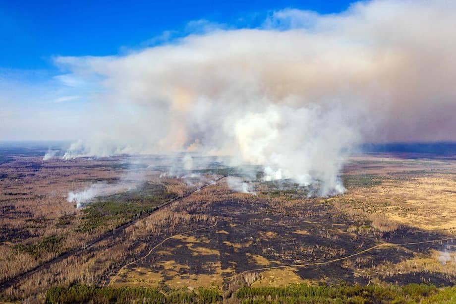 Esta fotografía aérea tomada el 12 de abril de 2020 muestra un incendio forestal que arde en una zona de exclusión de Chernobyl de 30 kilómetros (19 millas) en Ucrania, no lejos de la central nuclear. / AFP