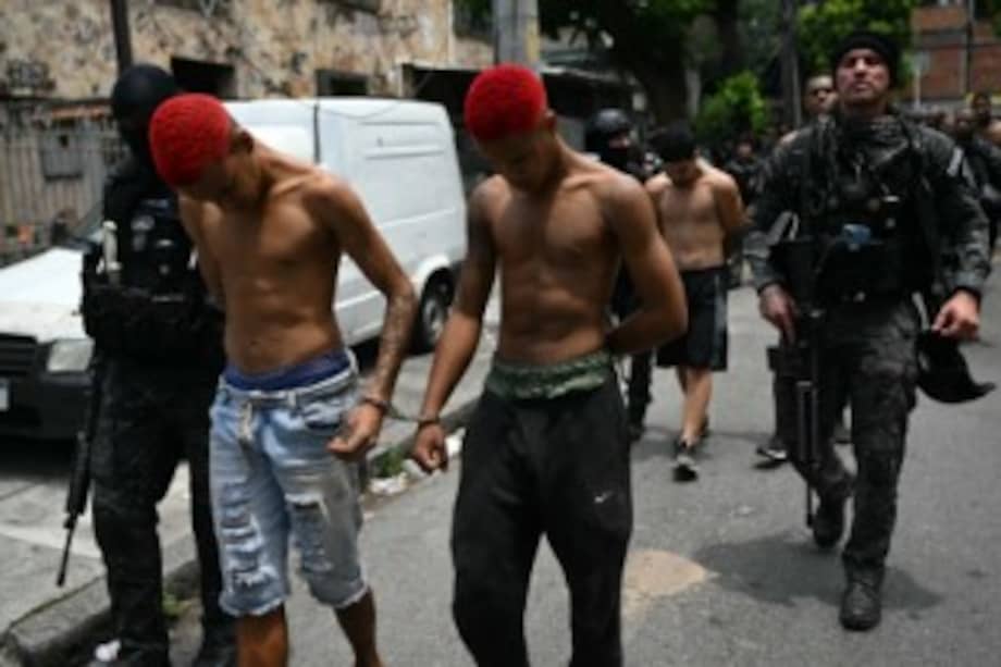 Agentes de policía escoltan a los sospechosos detenidos durante la Operación Contención fuera de la favela Vila Cruzeiro, en el complejo Penha, en Río de Janeiro.