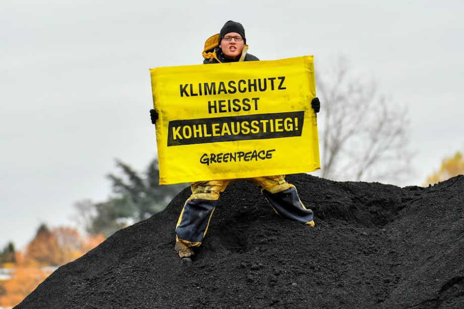 Un activista de Greenpeace muestra el cartel "Protección del clima significa acabar con el carbón" tras abordar un buque de carga de este mineral durante una protesta en el río Rin en el ámbito de la cumbre del clima COP23 en Bonn (Alemania). / Archivo EFE