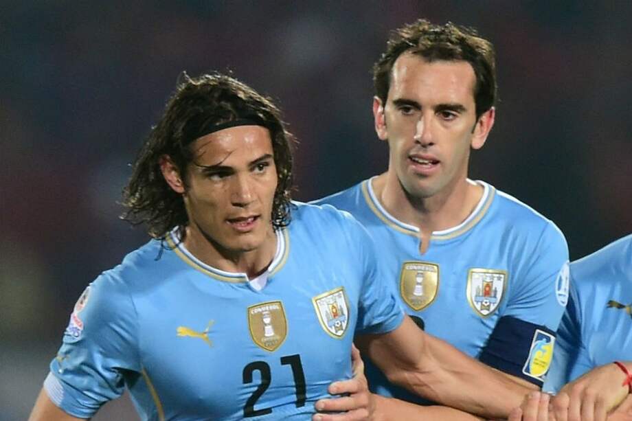 El defensa uruguayo, Diego Godín (derecha) tratando de contener a Cavani (izquierda) tras su expulsión. /AFP
