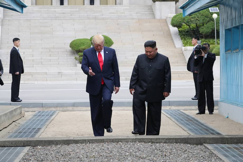 Fotografía de archivo del 30 de junio de 2019 del presidente de Estados Unidos, Donald Trump (i), y el líder norcoreano Kim Jong-un, cruzando la Línea de Demarcación Militar hacia el lado sur de la aldea Panmunjom en la Zona Desmilitarizada, que separa las dos Coreas (Corea del Norte).
