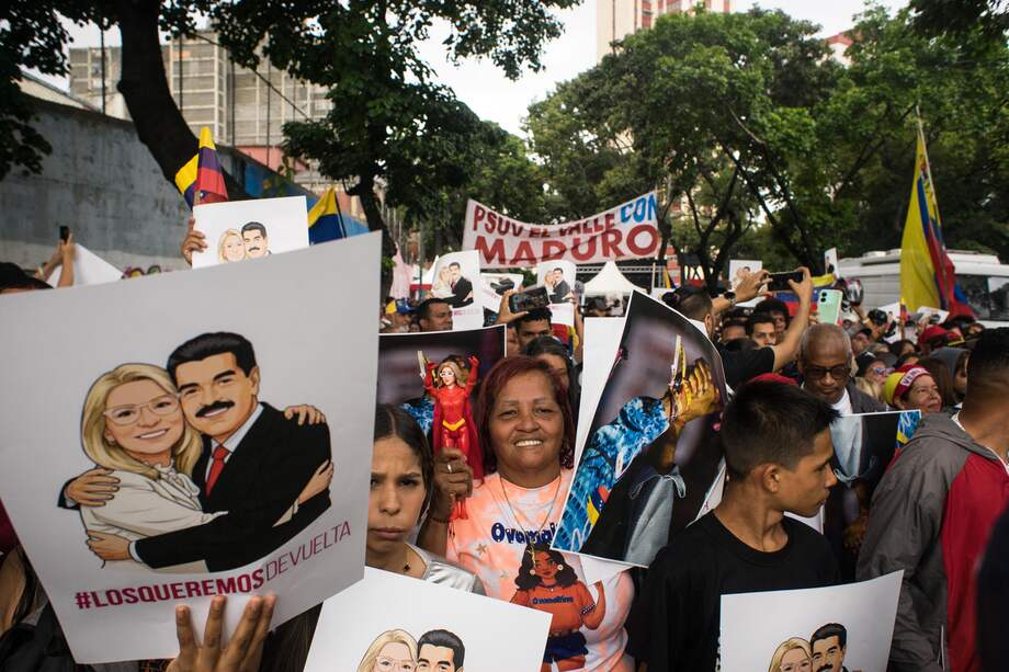 Personas sostienen carteles durante una manifestación en Caracas (Venezuela).