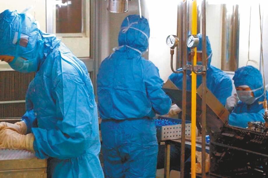 Staff members of Changchun Institute of Biological Products in Changchun, capital of northeast China's Jilin province, are engaged in producing such medicines as interferon which is helpful for residents to prevent from being infected with SARS Sunday, April 27, 2003. SARS has killed at least 131 people and sickened almost 3,000 people in mainland China. (AP Photo/Xinhua, Xu Jiajun)