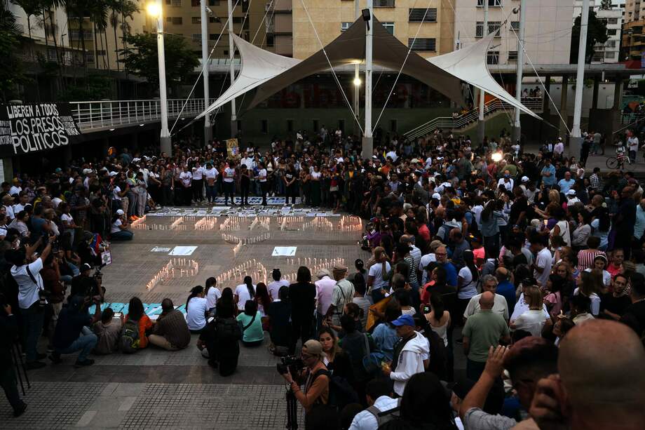 Personas rodean velas encendidas formando las palabras "Libertad y Paz" durante una vigilia convocada por la oposición exigiendo la libertad de los presos políticos.