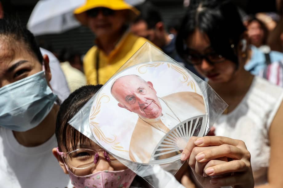Una niña muestra un abanico con el retrato del papa Francisco mientras hace cola para asistir a la misa que oficiará el Pontífice en el Estadio Nacional de Singapur.
