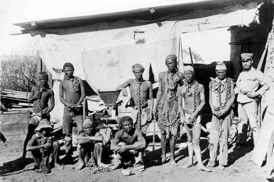 Un soldado (derecha), probablemente perteneciente a las tropas alemanas, supervisa a los prisioneros de guerra de Namibia.