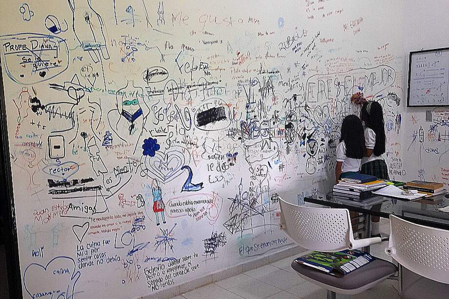 Estudiantes del Gimnasio de los Llanos escriben sus pensamientos en una pared de la oficina del rector, Juan Carlos Bayona.