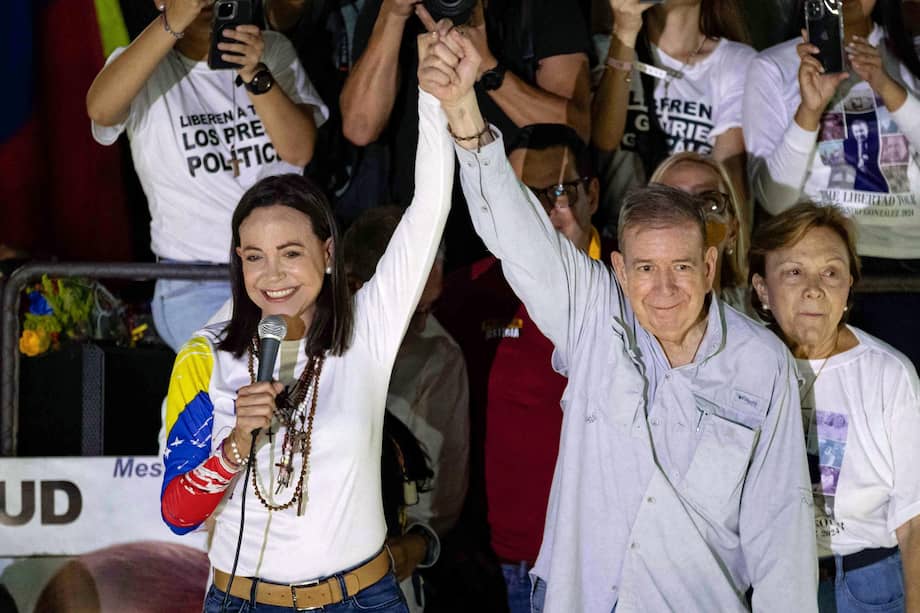 Fotografía de archivo del 25 de julio de 2024 que muestra a los líderes opositores de Venezuela María Corina Machado (i) y Edmundo González Urrutia saludando a simpatizantes en un evento de campaña, en Caracas (Venezuela).