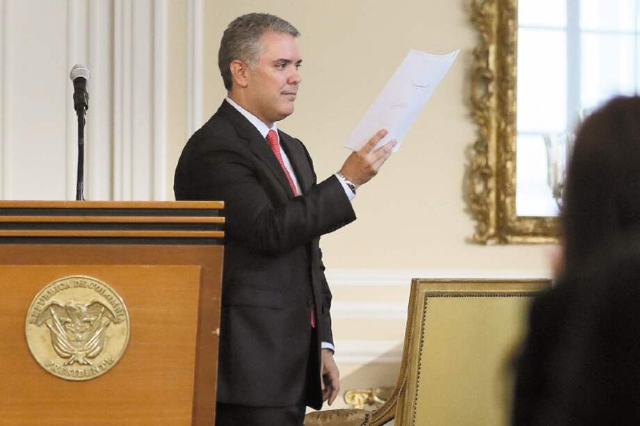 El presidente Iván Duque exhibe en sus manos el decreto en contra de la dosis mínima. / Presidencia