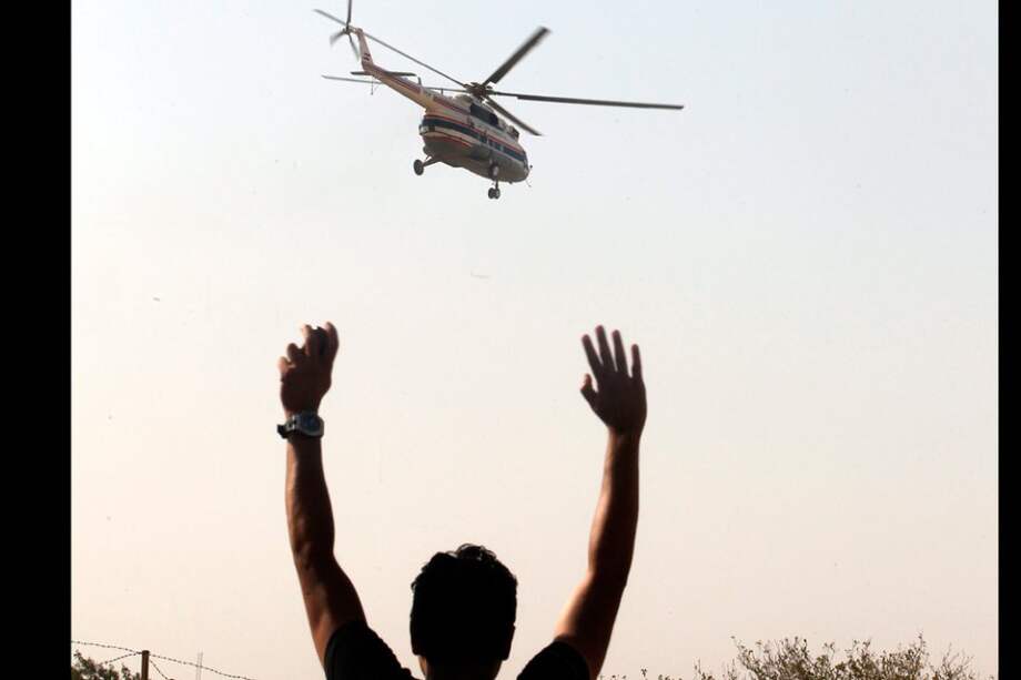 Un seguidor del expresidente egipcio Hosni Mubarak saluda hacia el helicóptero que lo traslada desde la prisión de Tora hacia el hospital militar Maadi