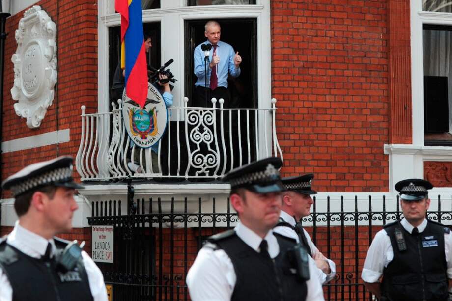 El fundador de WikiLeaks, el australiano Julian Assange (d), se dirige a los medios y a sus seguidores desde un balcón de la embajada de Ecuador en Londres, Reino Unido. / Afp.