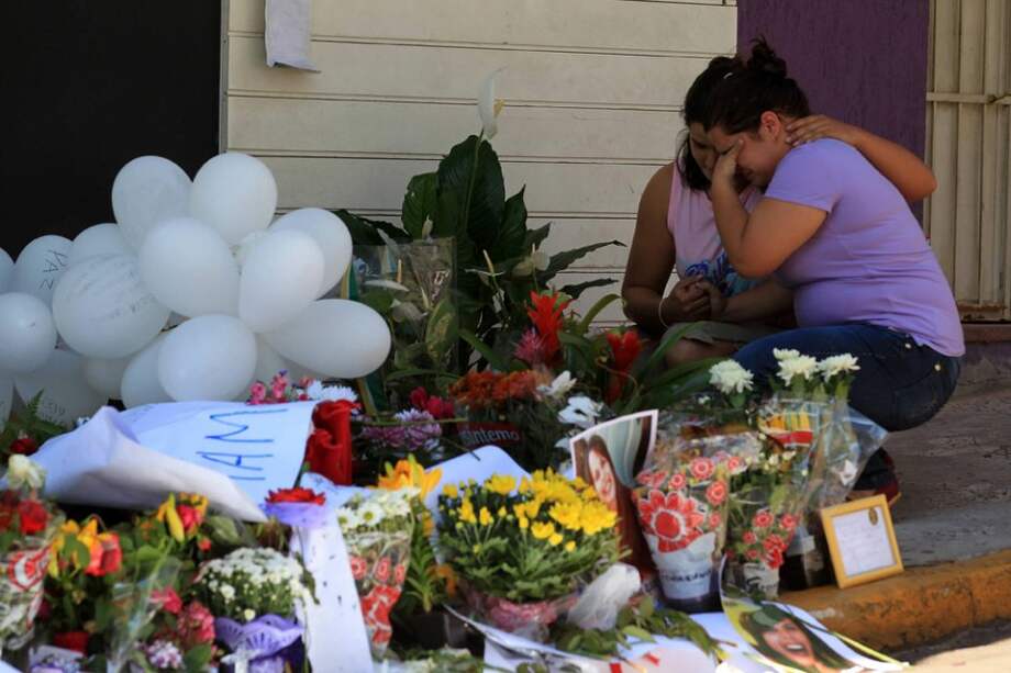 Altar con flores y fotografías en honor a las víctimas frente a la discoteca Kiss./ EFE