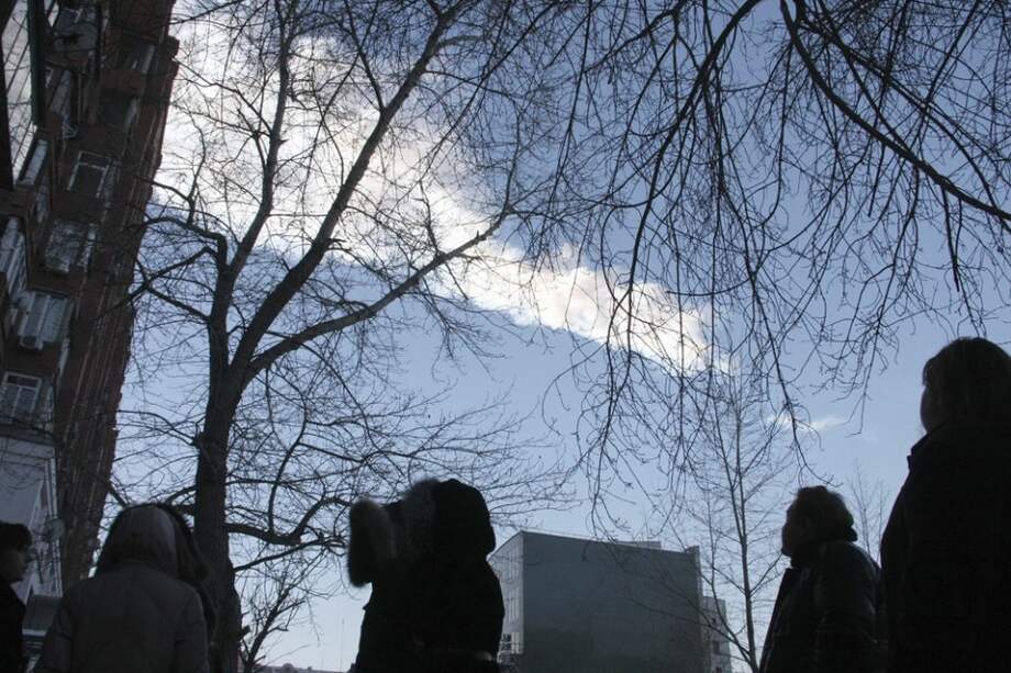 Varios curiosos observan la estela de vapor que dejó el meteorito que cayó en la región rusa de Cheliábinsk./ EFE