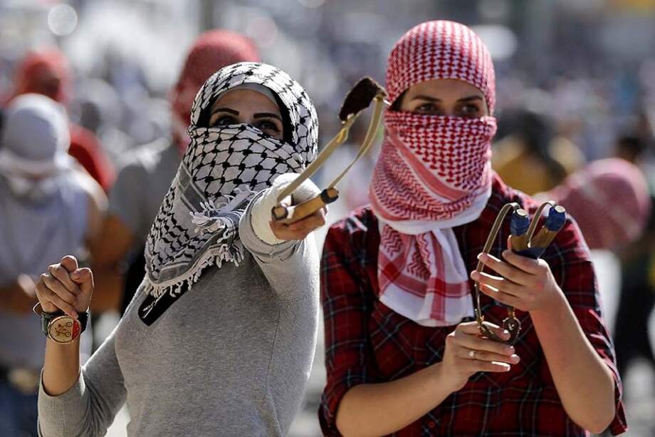 Dos manifestantes palestinas arrojan piedras a las fuerzas de seguridad israelíes en Belén. / EFE