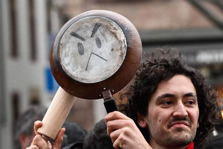 Un manifestante participa en un 'cacerolazo' contra el presidente francés, Emmanuel Macron, después de que promulgó la controversial ley de reforma de las pensiones.