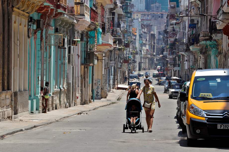 Una mujer camina con un coche para niño por una calle de la Habana, Cuba.