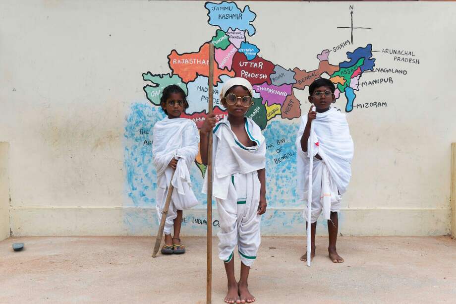 Estudiantes vestidos como Mahatman Gandhi, recuerdan el 150 aniversario de su nacimiento en Nueva Delhi. / AFP