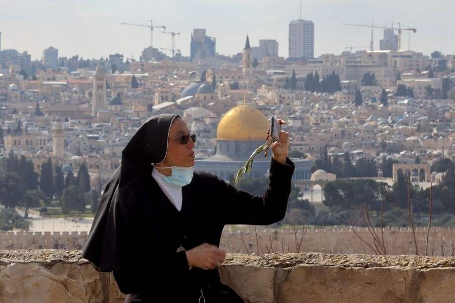 Una monja se toma una selfie durante una procesión del Domingo de Ramos en el Monte de los Olivos.