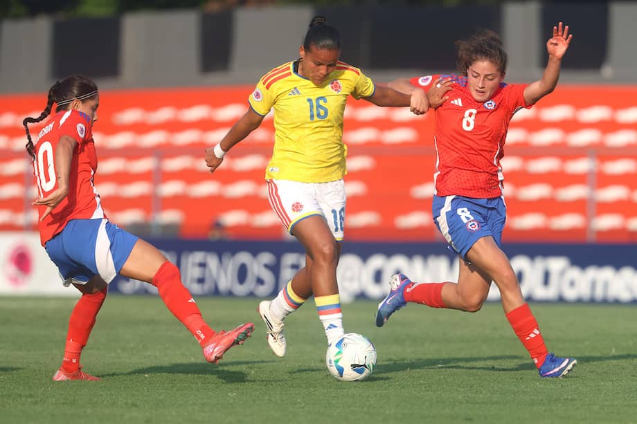 Ambar Figueroa (i) y Valentina Peña (d) de Chile disputan el balón Juana Ortegón de Colombia.