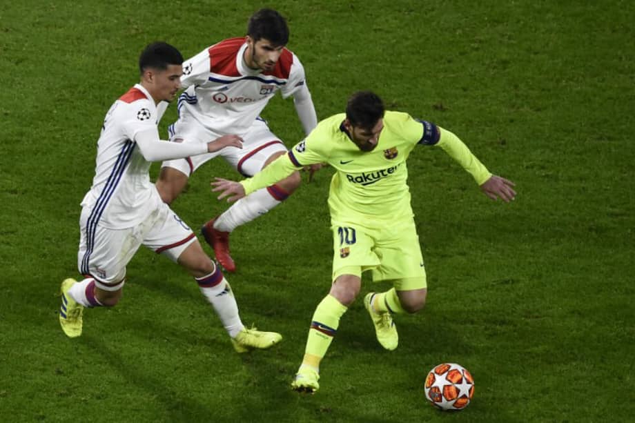 El argentino Lionel Andrés Messi (d), del Barcelona, marcado por dos jugadores, durante el partido contra Olympique de Lyon. / AFP