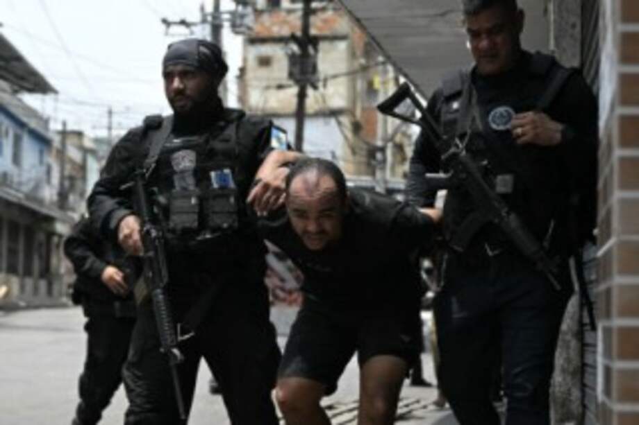 Un sospechoso es escoltado por agentes de policía tras ser detenido durante la Operación Contención en la favela Vila Cruzeiro, en el complejo Penha, en Río de Janeiro.
