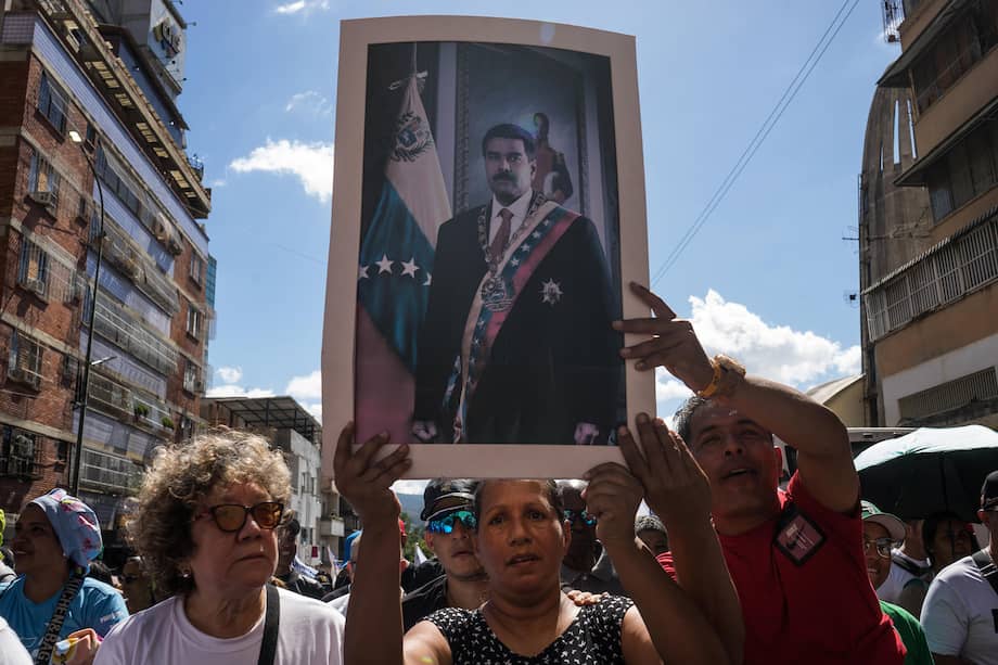 Personas sostienen un afiche con la imagen de Nicolás Maduro, capturado por Estados Unidos en Caracas a inicios de enero de este año.