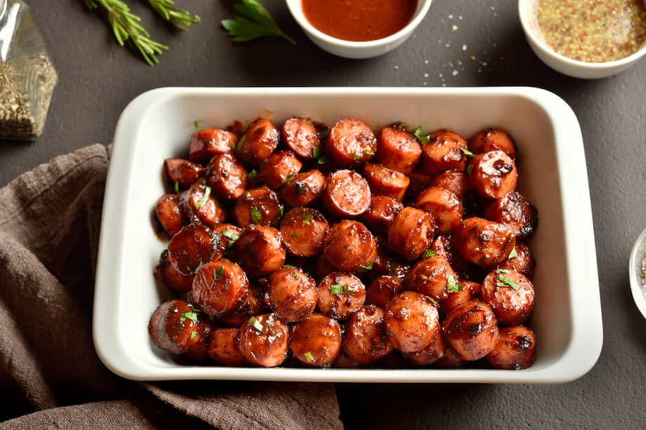 Sirve estas salchichas con panela picante decorándolas con cebollín por encima.
