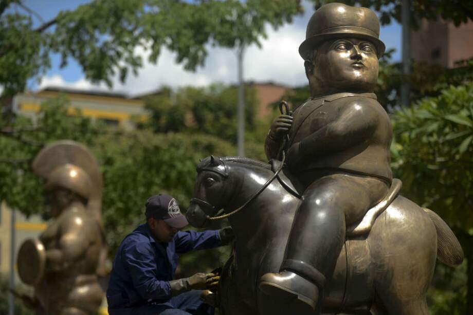 Un hombre trabaja en la restauración de una obra del artista colombiano Fernando Botero en el Parque Botero en Medellín