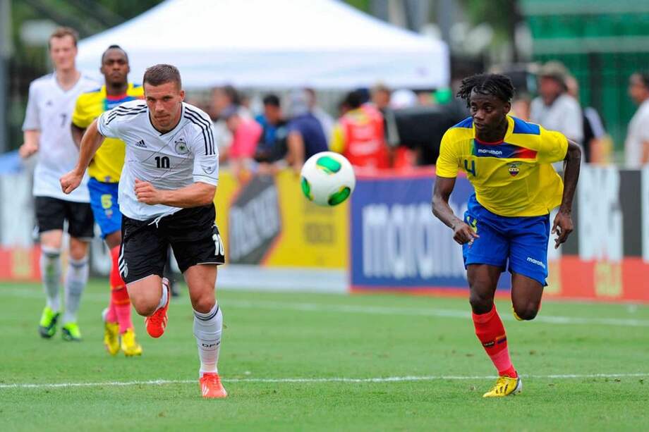 El jugador alemán Lukas Podolski (i) disputa un balón con Juan Carlos Paredes de Ecuador.