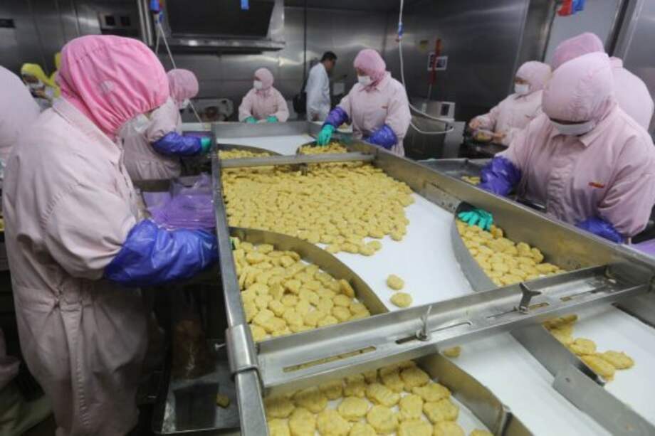 Empleados de la compañía Shanghai Husi Food, empresa proveedora de alimentos de las multinacionales estadounidenses McDonald’s y KFC. / AFP