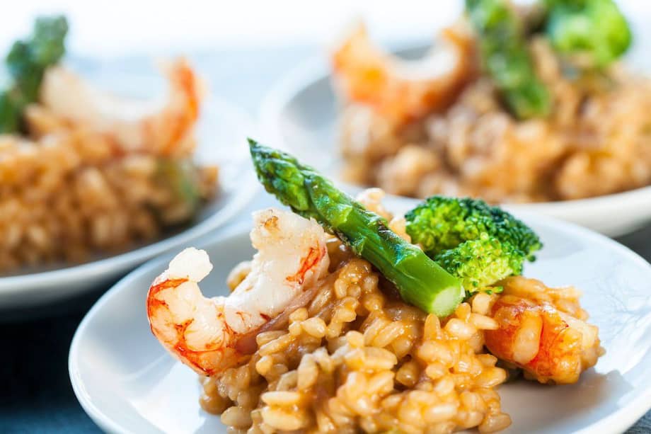 Sirve este risotto cremoso de coco con espárragos y camarones.