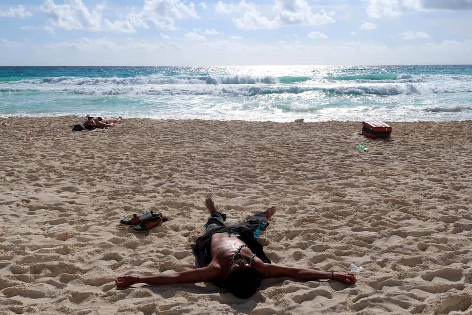 Turistas disfrutan de la playa este primer día de 2023, en el balneario de Cancún, en Quintana Roo (México).