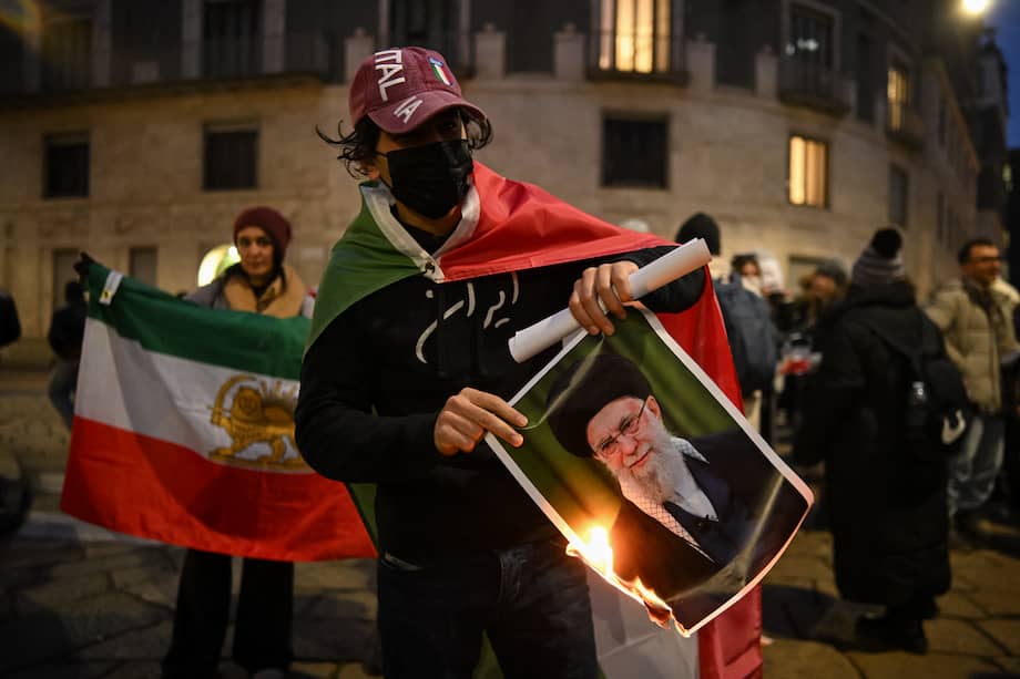 Un manifestante contra el régimen iraní quema una foto que muestra a Ali Khamenei, líder supremo de Irán.