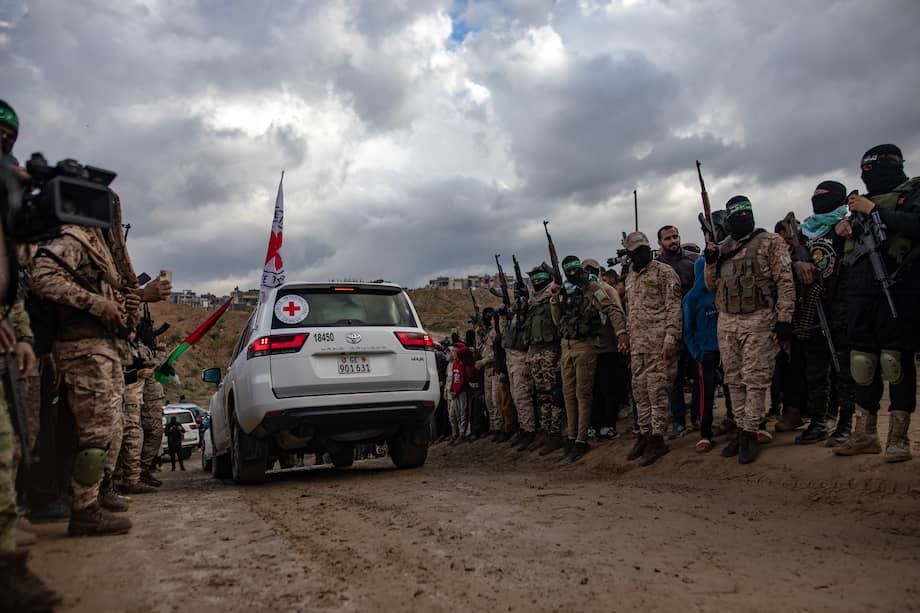 Civiles palestinos y combatientes de las Brigadas Izz ad-Din al-Qassam de Hamás asisten a la entrega de los cuerpos de cuatro rehenes israelíes a la Cruz Roja, en Khan Yunis, sur de la Franja de Gaza, el jueves 20 de febrero de 2025.