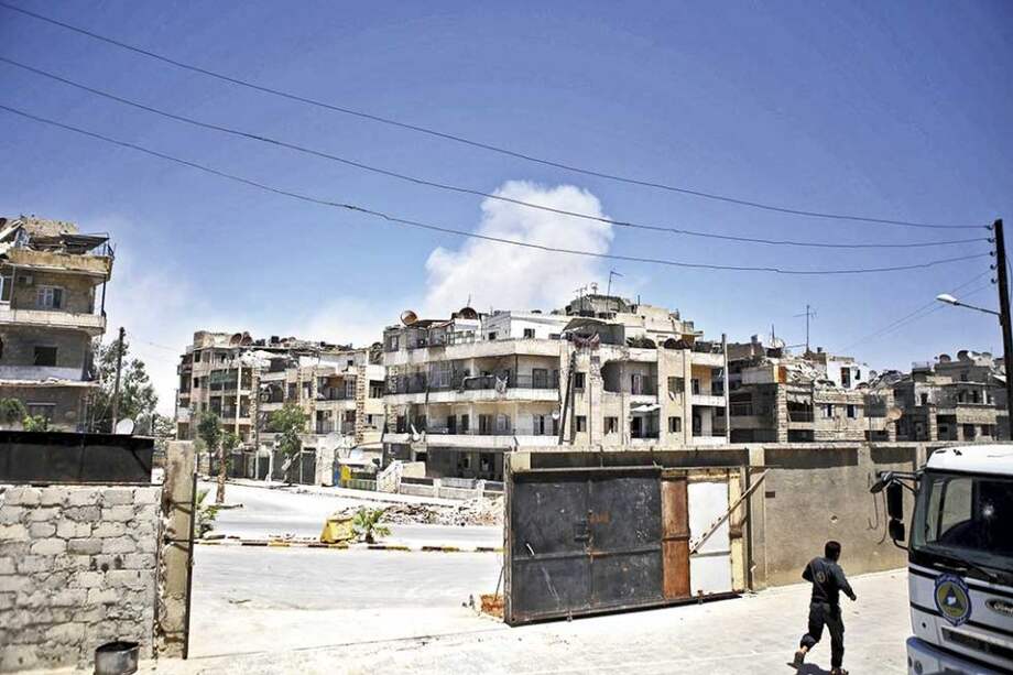 Un miembro de la defensa civil corre hacia un camión de la organización en la ciudad siria de Alepo./ Mauricio Morales