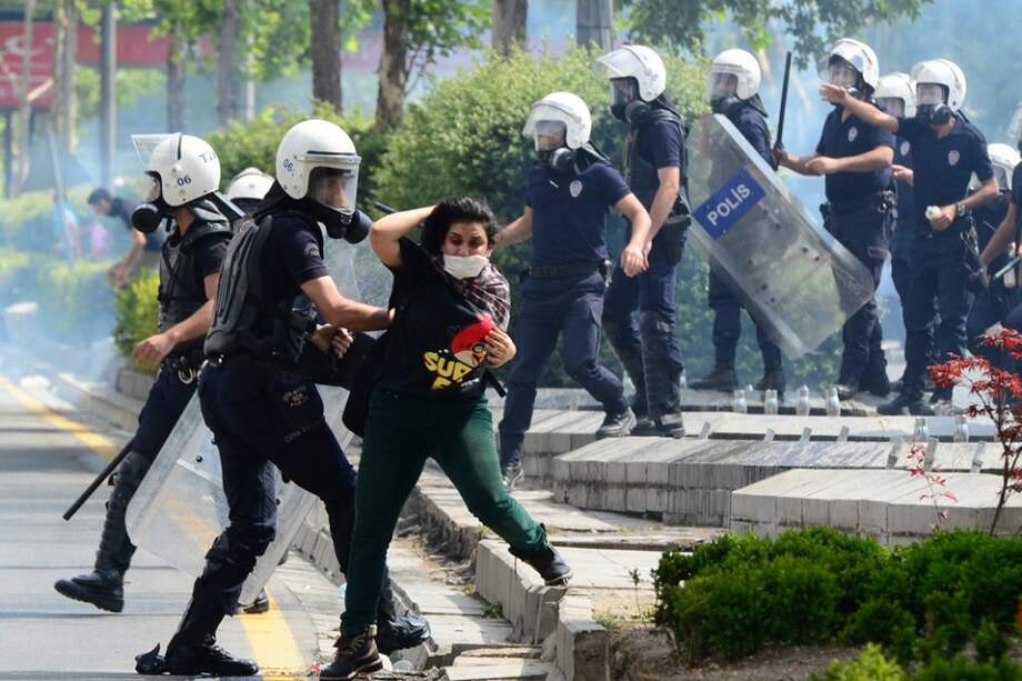 Un policía antidisturbios forcejea con una manifestante durante una de las revueltas que sacuden Turquía desde el viernes pasado. / EFE