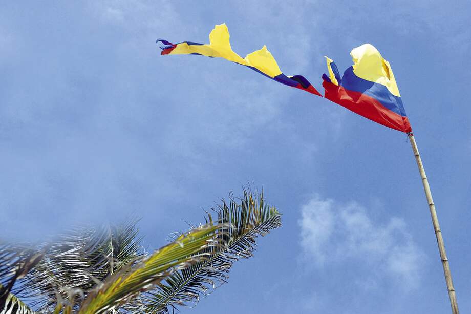 Una bandera colombiana es ondeada con fuerza por el viento de la isla antillana, que la ha ido despedazando con el tiempo, como se ha ido despedazando el patriotismo en el corazón de algunos raizales. / Luis Ángel