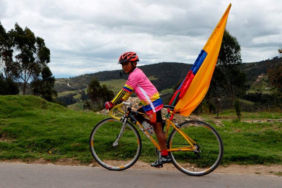 Un niño monta su bicicleta y celebra el título de campeón del colombiano Nairo Quintana en el Giro de Italia.