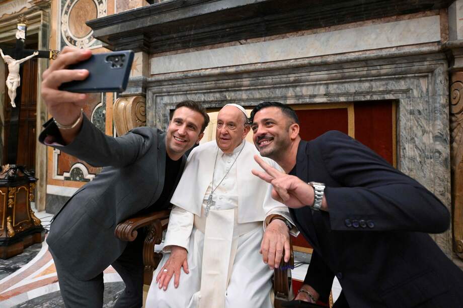 El papa Francisco posando para una selfi con el dúo de comediantes italianos Pio (L) e Amedeo (R) con motivo de un encuentro con más de 100 comediantes de todo el mundo, en la Sala Clementina de la Ciudad del Vaticano, en la Ciudad del Vaticano, el 14 de junio de 2024, antes de la partida del pontífice hacia la Cumbre del G7 en el sur de Italia.