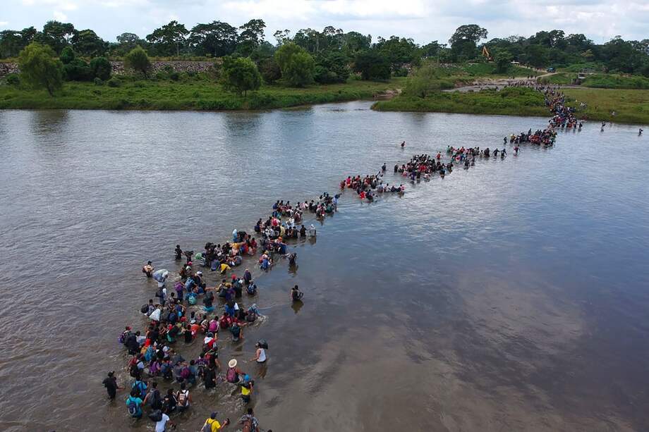Salvadoreños cruzan el río Suchiate hacia México, desde Guatemala, teniendo como meta a los Estados Unidos. / AFP